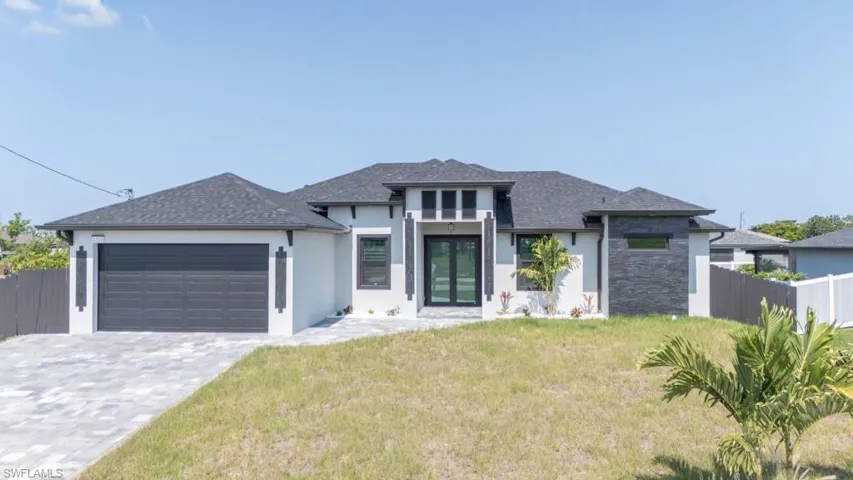 Prairie-style home with a garage, stucco siding, a shingled roof, decorative driveway, and french doors