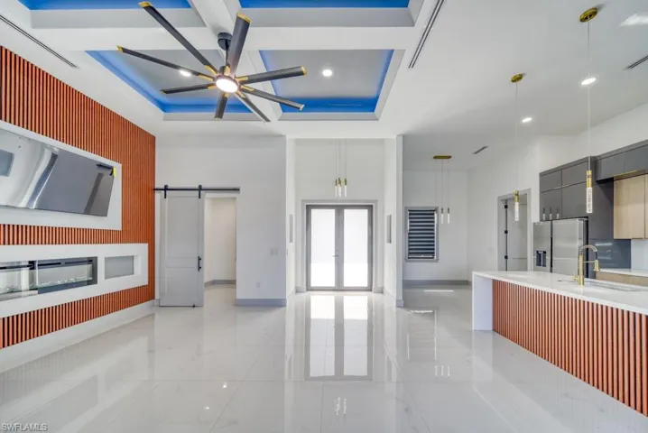 Kitchen with stainless steel fridge with ice dispenser, a sink, modern cabinets, baseboards, and coffered ceiling