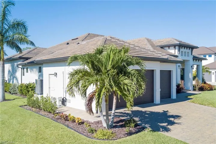 View of front facade featuring decorative driveway, an attached garage, a front yard, and a tiled roof