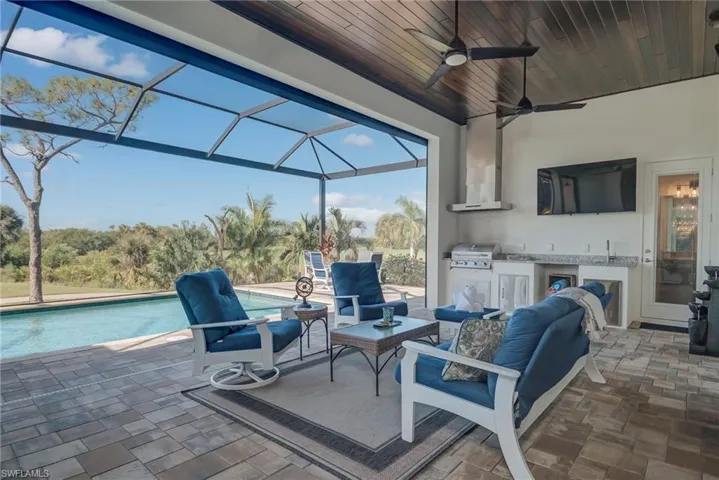 View of patio / terrace featuring a lanai, a sunroom, an outdoor pool, an outdoor hangout area, and a ceiling fan