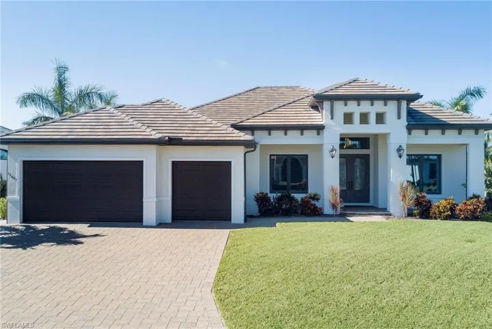 Prairie-style home featuring decorative driveway, a front lawn, a garage, and a tiled roof