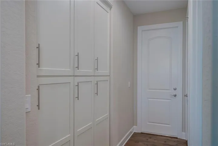 Hallway with dark wood-style floors and baseboards
