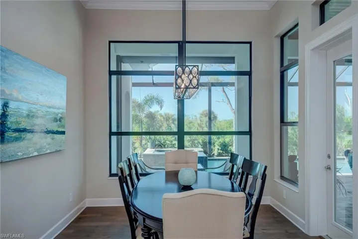 Dining room featuring dark wood finished floors and ornamental molding