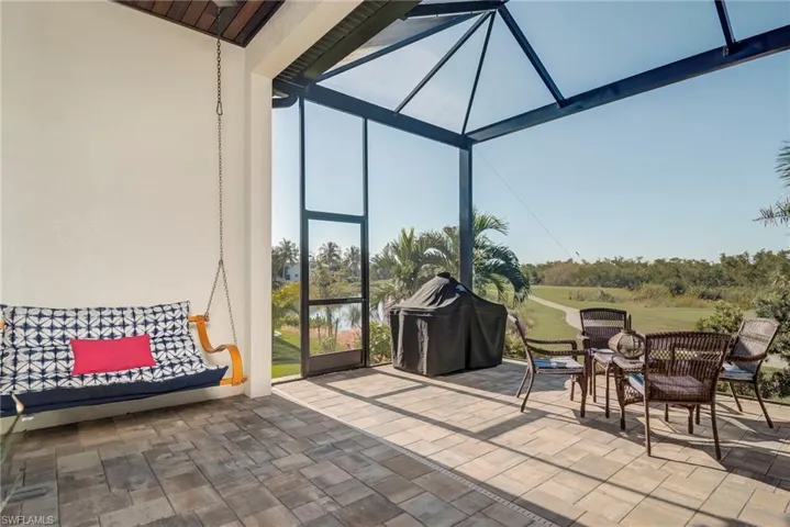 View of patio with a sunroom, area for grilling, and a water view