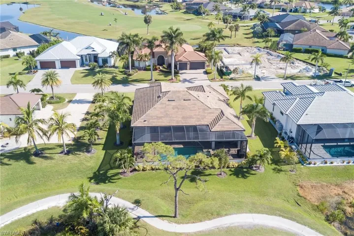Aerial view of residential area with a nearby body of water and a golf course