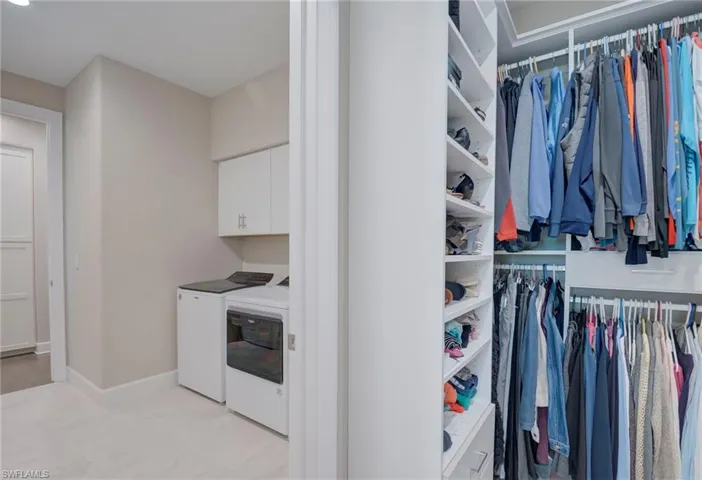 Washroom featuring washer and dryer and cabinet space
