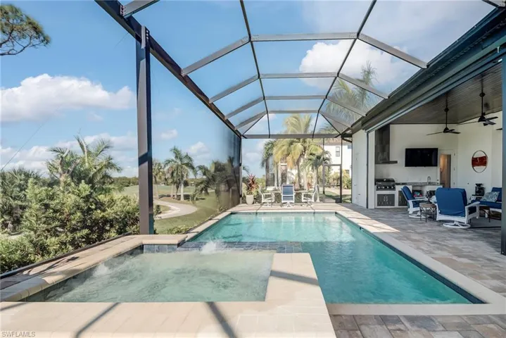 View of pool featuring a ceiling fan, a sunroom, a lanai, a pool with connected hot tub, and a patio