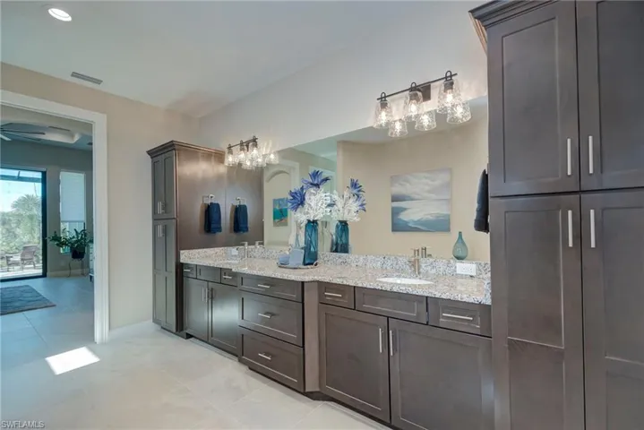 Bathroom with double vanity, light tile patterned floors, and recessed lighting