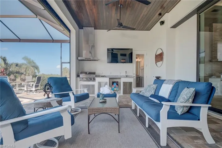 View of patio / terrace with a sunroom, a lanai, area for grilling, and a ceiling fan