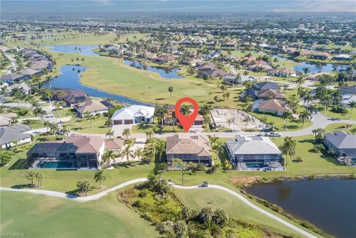View of property location with a nearby body of water, a golf course, and nearby suburban area