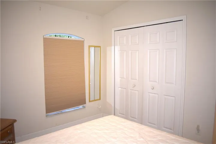 Unfurnished bedroom with a closet and vaulted ceiling