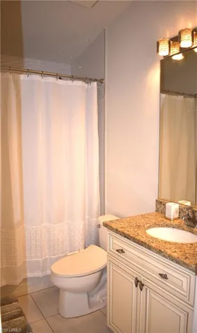Bathroom with tile patterned flooring, vanity, and toilet