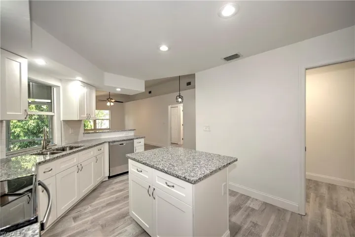 Kitchen with recessed lighting, stainless steel dishwasher, a kitchen island, black electric range, and visible vents