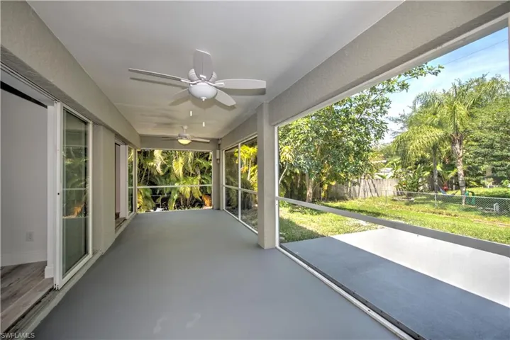 Unfurnished sunroom with a ceiling fan and a wealth of natural light