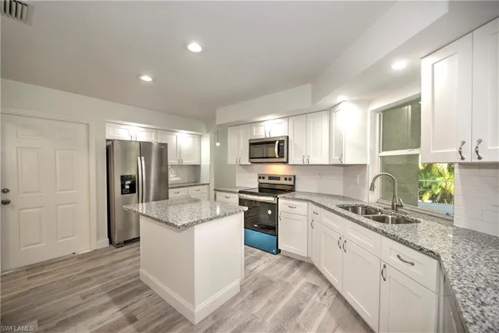 Kitchen featuring a sink, light wood-style floors, tasteful backsplash, visible vents, and appliances with stainless steel finishes