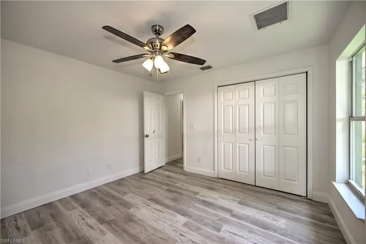 Unfurnished bedroom featuring a closet, visible vents, baseboards, and light wood-style floors