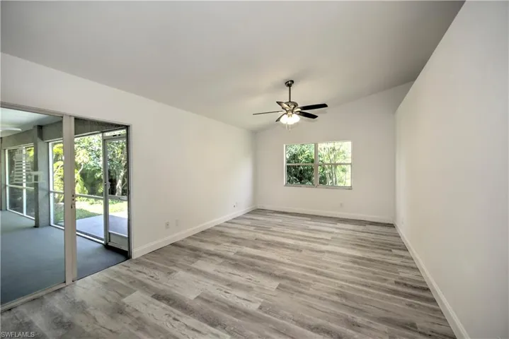 Unfurnished room with ceiling fan, wood finished floors, and baseboards