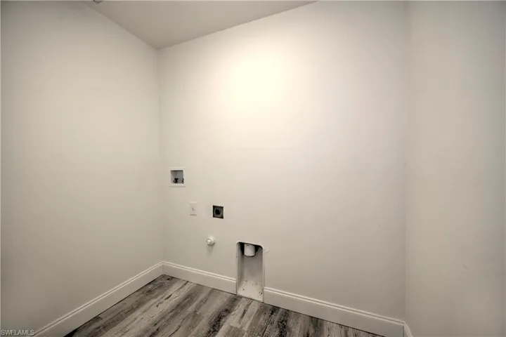 Laundry room featuring hookup for an electric dryer, washer hookup, light wood-style flooring, baseboards, and laundry area