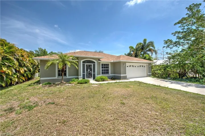 Mediterranean / spanish home featuring stucco siding, a front yard, driveway, and an attached garage