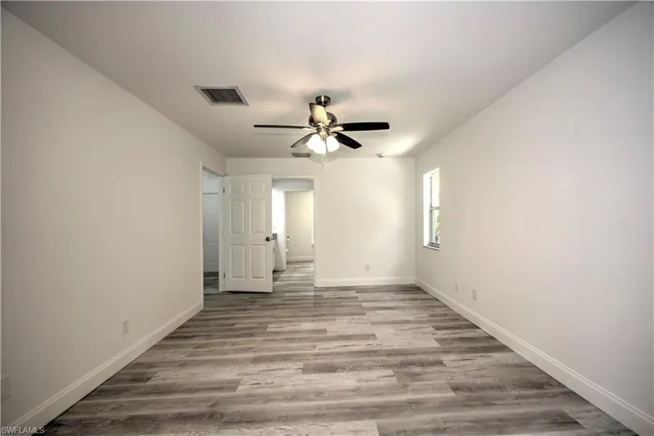 Spare room featuring baseboards, visible vents, wood finished floors, and ceiling fan