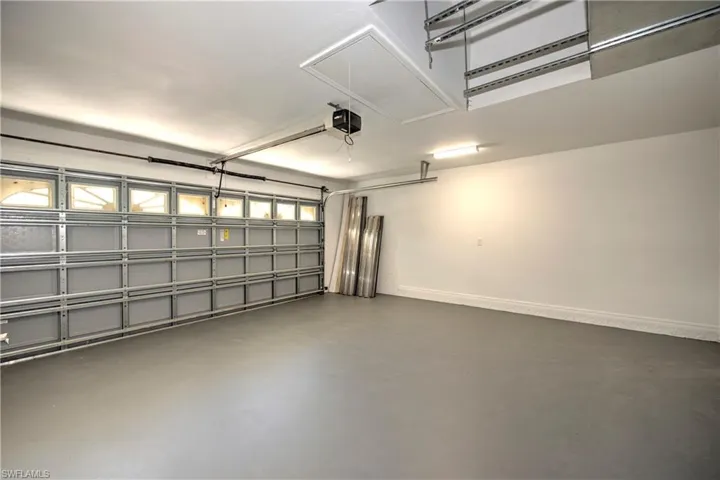 Garage with baseboards and a garage door opener