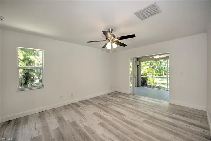 Empty room with visible vents, ceiling fan, light wood-style flooring, and baseboards
