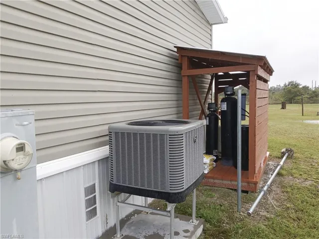 Exterior view of a central AC unit and water system with cover