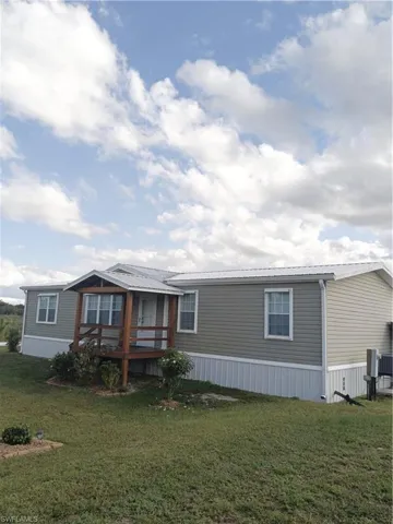 Manufactured / mobile home with a metal roof / front porch