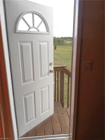 Doorway to outside from bonus room with wood finished floors