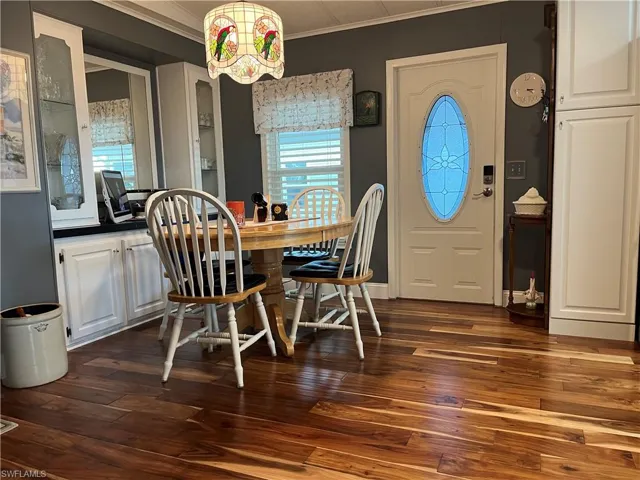 Dining room with a chandelier, dark hardwood / wood-style floors, and ornamental molding