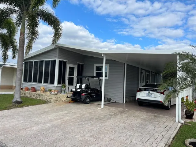 View of front of property with a carport and a sunroom