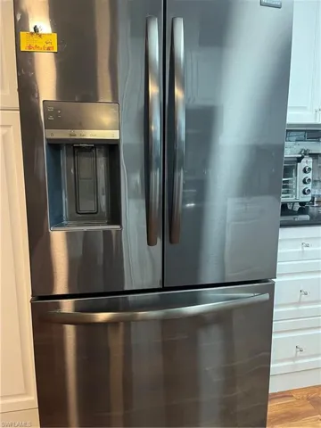 Interior details featuring black refrigerator and white cabinetry