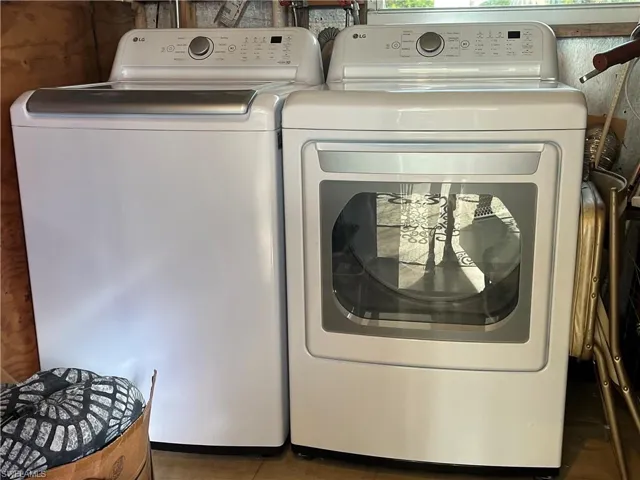 Laundry area featuring washing machine and dryer and dark tile patterned floors