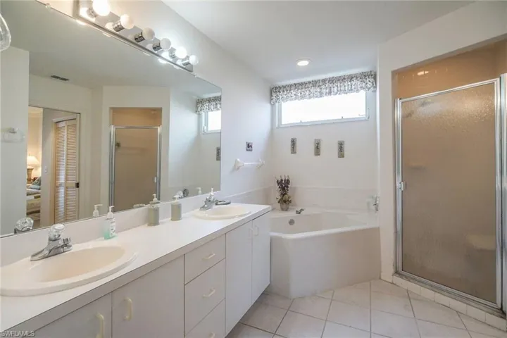 Bathroom featuring vanity, tile patterned floors, and independent shower and bath