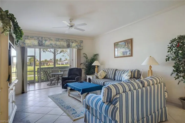 Tiled living room featuring ornamental molding and ceiling fan