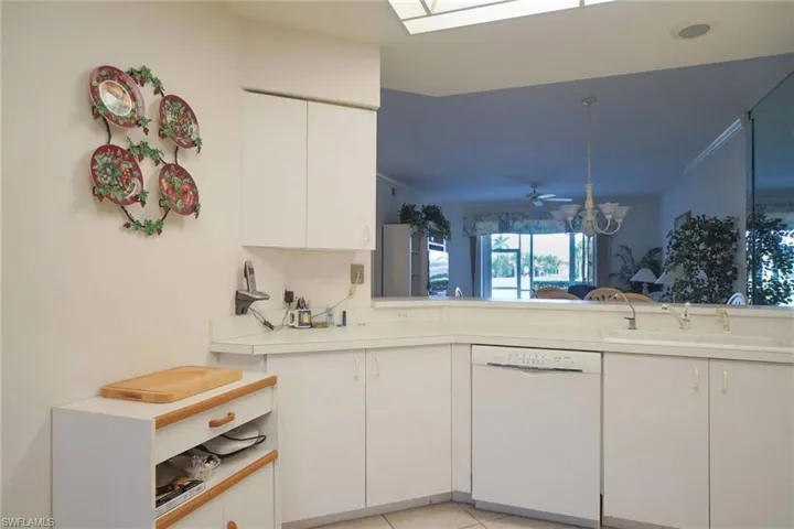Kitchen featuring white cabinetry, sink, ceiling fan, light tile patterned floors, and dishwasher