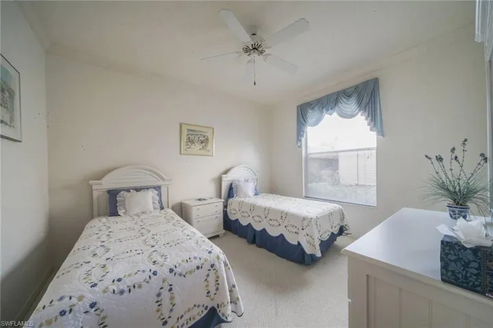 Bedroom with ornamental molding, ceiling fan, and carpet floors