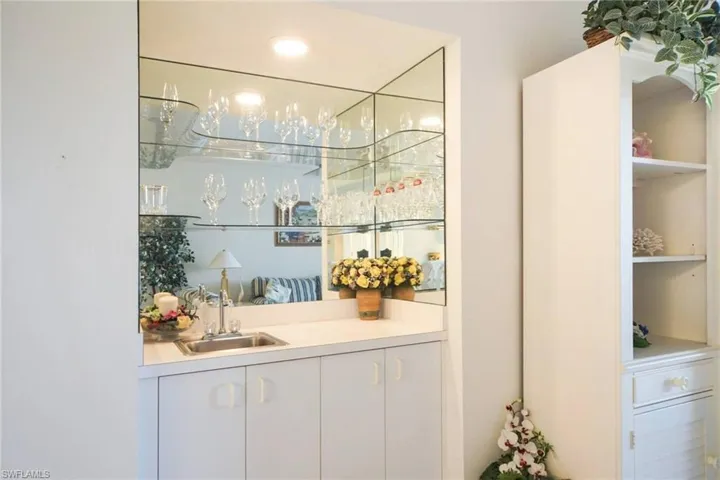 Bar featuring sink and white cabinets