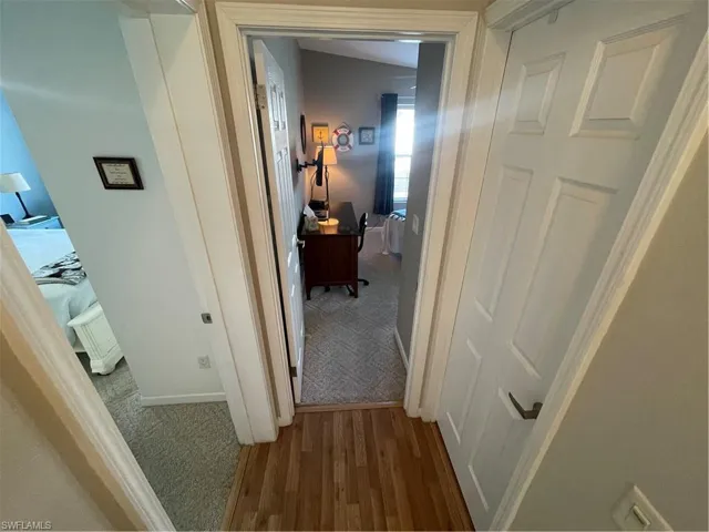 Corridor with carpet and wood finished floors