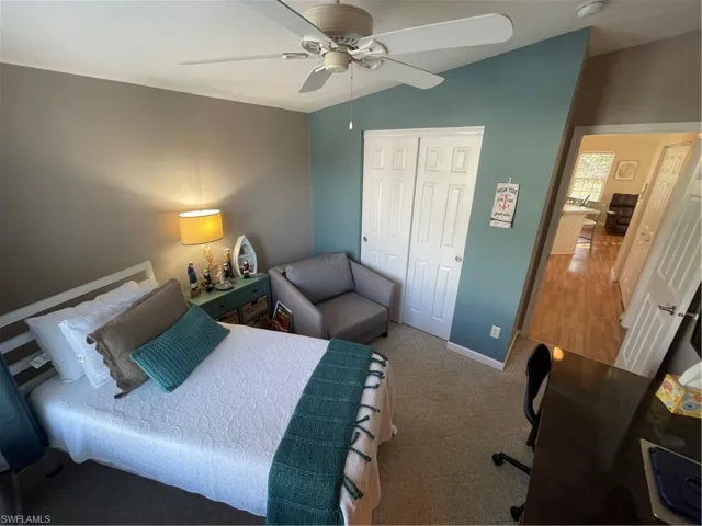 Bedroom featuring lofted ceiling, a closet, a ceiling fan, and carpet