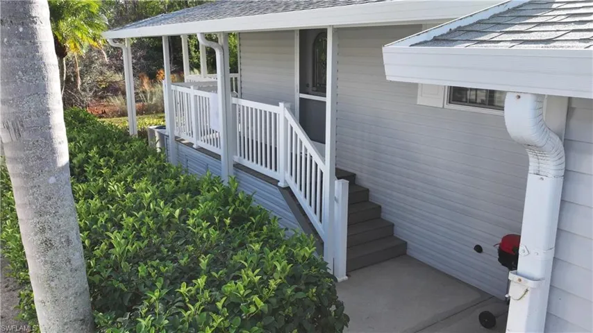 Doorway to property with a shingled roof