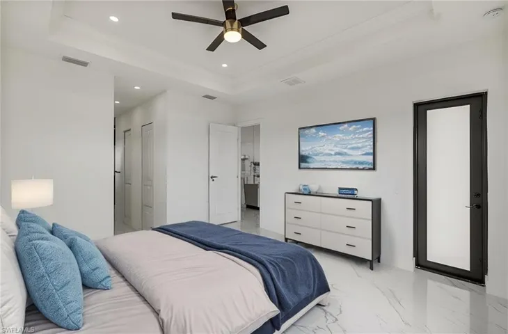 Bedroom featuring visible vents, a raised ceiling, ornamental molding, marble finish floor, and recessed lighting