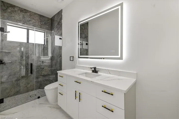 N.3 Guess/pool Bathroom featuring toilet, marble finish floor, a marble finish shower, and vanity