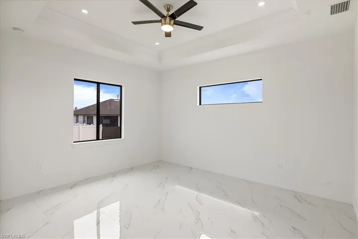 Master room with visible vents, baseboards, a ceiling fan, a tray ceiling, and recessed lighting