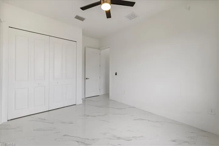 bedroom n.2 with marble finish floor, baseboards, visible vents, and a closet
