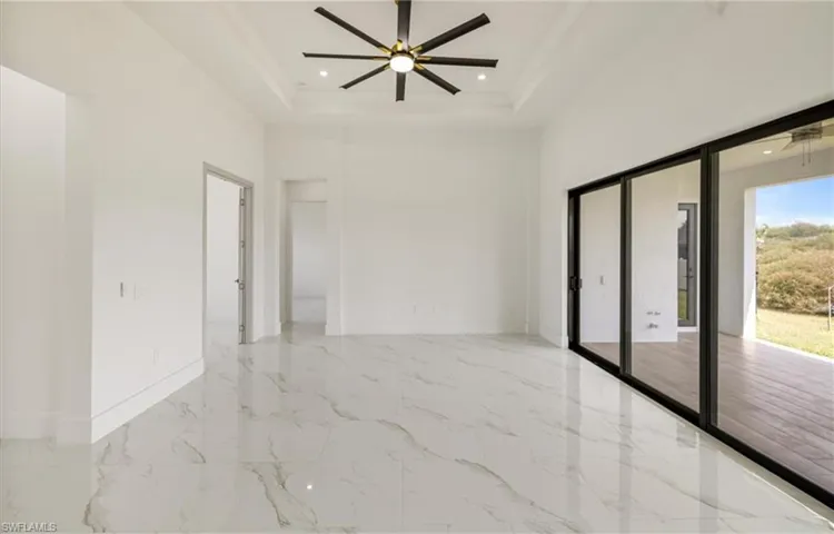 Spare room featuring baseboards, marble finish floor, a tray ceiling, and crown molding