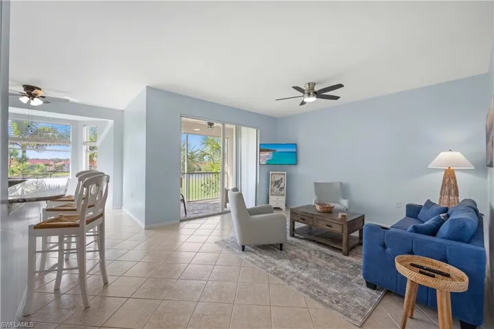 Tiled living room featuring ceiling fan and a healthy amount of sunlight