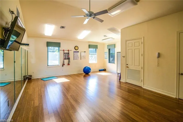 Exercise room featuring hardwood / wood-style flooring, plenty of natural light, and ceiling fan
