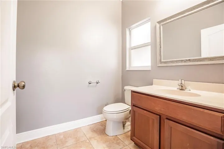 Bathroom featuring tile patterned flooring, vanity, and toilet