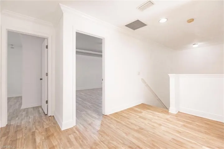 Unfurnished room with light wood-type flooring and crown molding